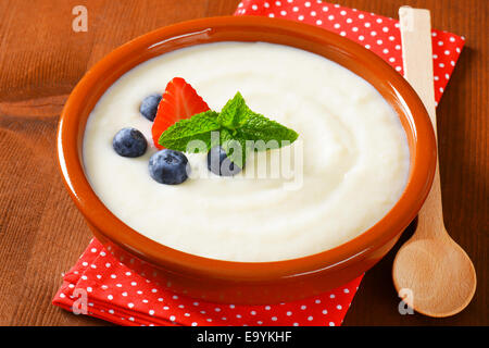 La semola liscia porridge servito nel piatto di terracotta con frutta fresca Foto Stock