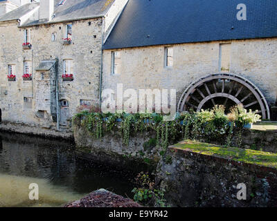 Il pittoresco undershot waterwheel e gli antichi edifici dietro l'Arazzo di Bayeux museum di Bayeux in Normandia. Foto Stock