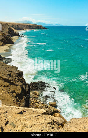 La Pared spiaggia per il surf e il Parque Natural Jandia montagne al di là sulla costa SW; La Pared, Fuerteventura, Isole Canarie, Spagna Foto Stock