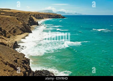 La Pared spiaggia per il surf e il Parque Natural Jandia montagne al di là sulla costa SW; La Pared, Fuerteventura, Isole Canarie, Spagna Foto Stock