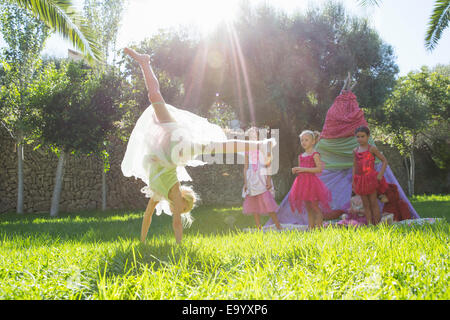 Girls Watching amico in costume fata facendo appoggiate in giardino Foto Stock
