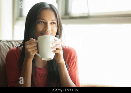 Donna con il caffè a casa Foto Stock