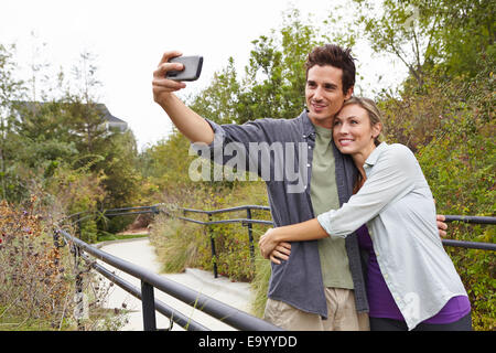 Giovane tenendo selfie in posizione di parcheggio Foto Stock