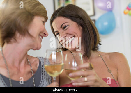 Due donne mature, bere vino e ridere Foto Stock