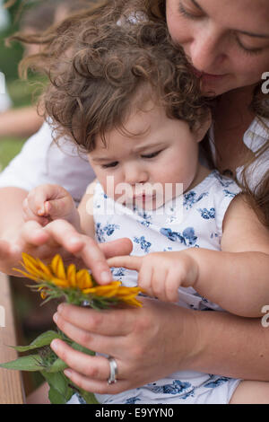 Madre e figlia guardando fiore insieme Foto Stock