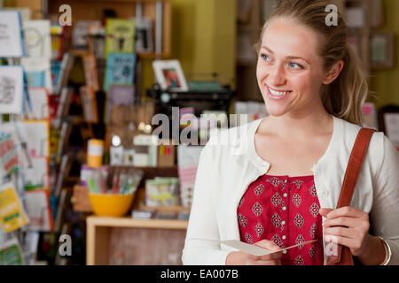 Femmina la navigazione del cliente biglietti di auguri nella cartoleria Foto Stock