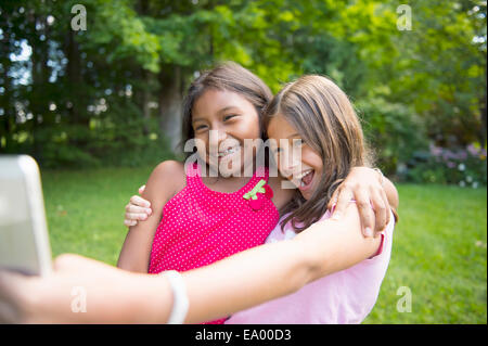 Le ragazze prendendo selfie in giardino Foto Stock