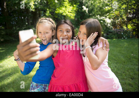 Le ragazze prendendo selfie in giardino Foto Stock