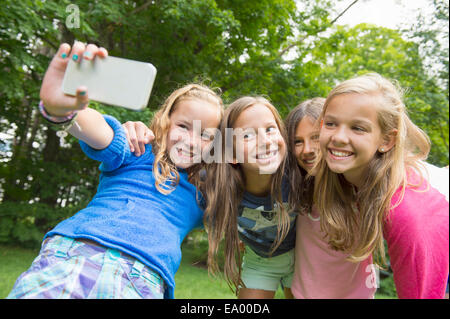 Le ragazze prendendo selfie in giardino Foto Stock