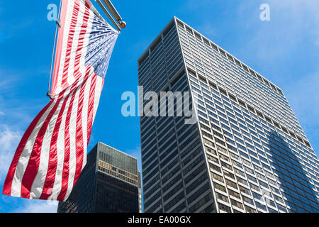 Basso angolo di visualizzazione dei grattacieli e bandiera americana nel quartiere finanziario di Manhattan, New York, Stati Uniti d'America Foto Stock