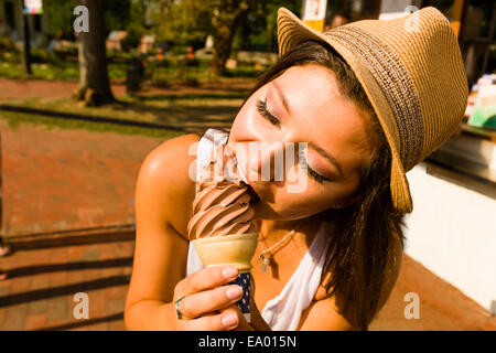 Giovane donna a mangiare il gelato in cono park Foto Stock