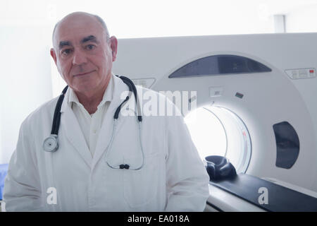 Dottore in piedi accanto al CT scanner Foto Stock