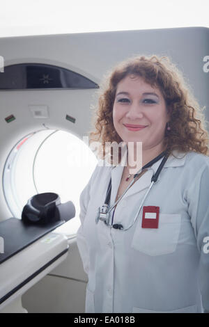 Dottore in piedi accanto al CT scanner Foto Stock