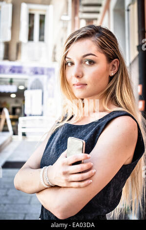 Ritratto di fiducioso giovane donna su una strada di città Foto Stock