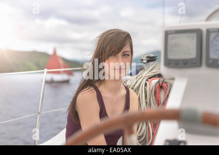 Giovane donna rilassante su yacht, guardando lontano Foto Stock