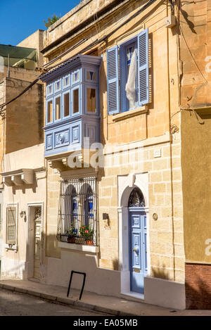 Tipica Maltese tradizionale casa di città della costruzione in pietra arenaria con balcone chiuso. Foto Stock