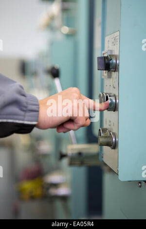Operaio di fabbrica sul pannello di controllo del macchinario Foto Stock