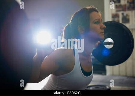 Sollevamento donna barbell in palestra Foto Stock