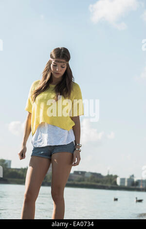 Giovane donna che indossa la parte superiore gialla e hot pants Foto Stock