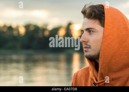 Giovane uomo che indossa orange top con cappuccio Foto Stock