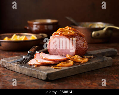 Cena di Natale. Piccolo arrosto di marmellata di arance gammon sul tagliere Foto Stock