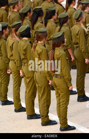 Donne israeliane soldati levarsi in piedi nelle linee durante una cerimonia Foto Stock