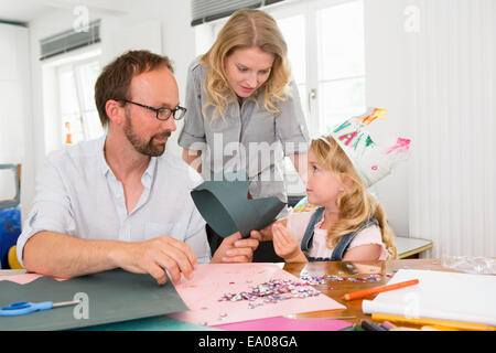 Famiglia rendendo corone di carta Foto Stock