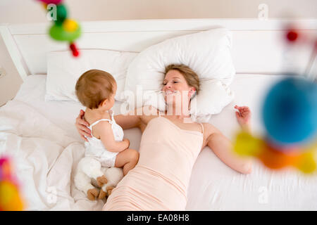 Madre e figlia Bambino giacente sul letto, angolo alto Foto Stock