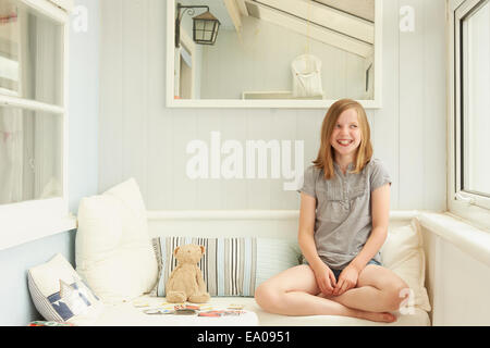 Ritratto di ragazza cerca lateralmente in appartamento di vacanza portico Foto Stock