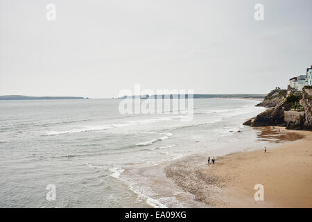 Vista in lontananza persone che passeggiano sulla spiaggia di South Beach, Tenby, Galles Foto Stock