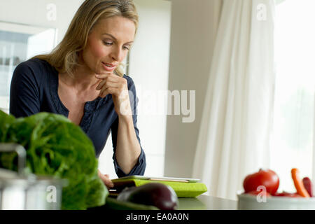 Donna matura con tavoletta digitale Foto Stock