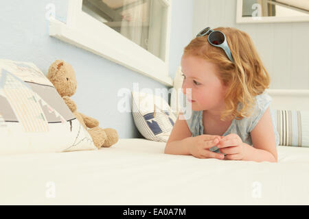 Ritratto di ragazza distesa su Appartamento di vacanza sedile con Teddy bear Foto Stock