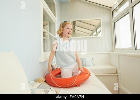 Ragazza che gioca con la vita della cinghia sulla appartamento di vacanza sede Foto Stock