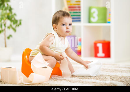 Kid ragazzo seduto sul vaso con carta igienica Foto Stock