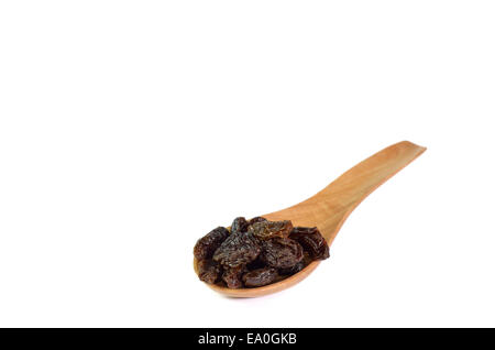 Uva passa e un cucchiaio di legno isolato su sfondo bianco Foto Stock