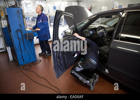 Berlino, Germania. 4 Novembre, 2014. Un membro dello staff del TUV, ispezione tecnica associazione per le automobili e i prodotti di consumo, insepects una vettura al test TUV e la stazione di servizio a Berlino, Germania, 4 novembre 2014. Foto: Joerg Carstensen/dpa/Alamy Live News Foto Stock