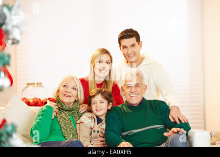 La famiglia felice con bambini e anziani a Natale seduti a casa Foto Stock