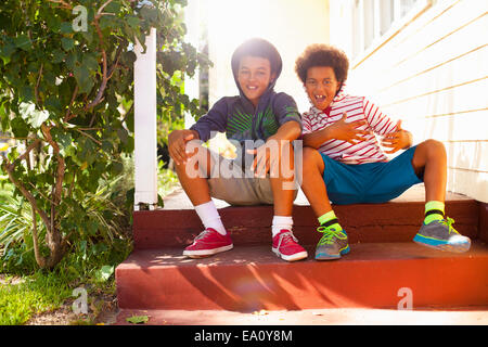 Ritratto di due fratelli seduti sulla veranda passi