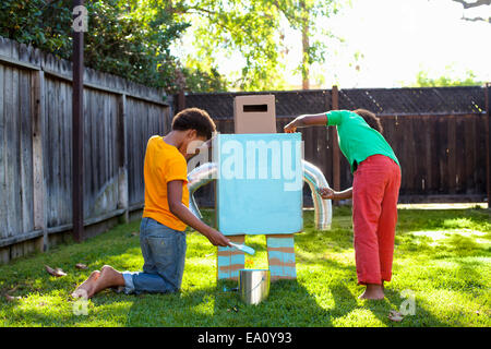 Due fratelli pittura fatta in casa il robot azzurro in giardino Foto Stock