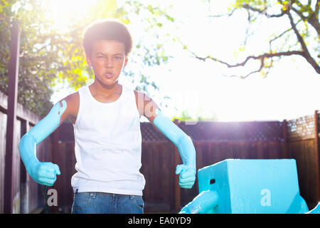 Ritratto di ragazzo con dipinto di blu le braccia davanti casa fatta robot Foto Stock