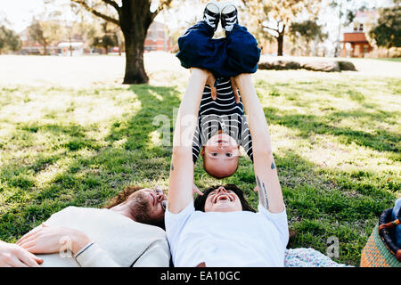 Coppia con bambino sulla coperta picnic nel parco Foto Stock