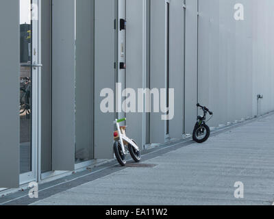 Due biciclette per bambini appoggiati contro 8 House, Copenhagen, Danimarca Foto Stock