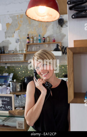 Metà donna adulta su telefono cafe Foto Stock