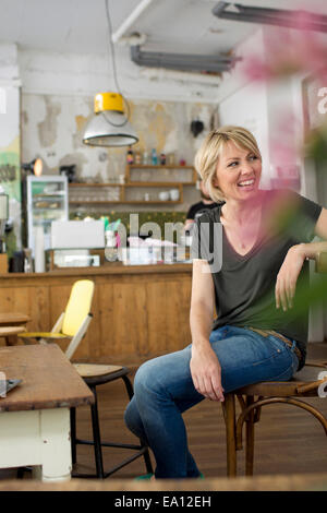 Metà donna adulta in seduta cafe Foto Stock