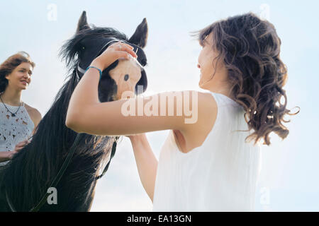 Basso angolo vista della giovane donna a cavallo Foto Stock