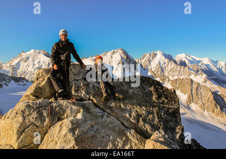 Ragazzo giovane e suo padre sul vertice dopo la scalata Aiguille du Tour nelle alpi francesi poco dopo l'alba. Foto Stock