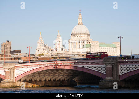 Red London double decker bus going over Blackfriars Bridge with St Pauls cathedral and views of London in October Foto Stock