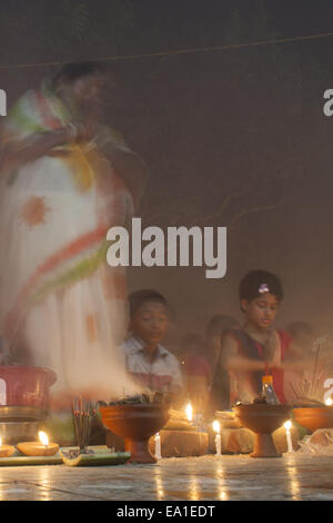 Narayangonj, Bangladesh. 4 Novembre, 2014. La gente della comunità indù (Malaysia) celebra "Rakher Upobas''a cultura in ogni mese in Bengali Kartik. Si tratta di un rapido giorno per mettere al sicuro tutti i propri familiari da tutti i tipi di problemi di nero. Uomo indù e le donne stanno celebrando questo festival rituale mediante illuminazione lampade e candele da soli al tramonto con qualche regalo (frutta, dolci, di cocco, di latte di vacca ecc.) per la loro convinzione "Baba Loknath'' Indù uno del dio. E ogni fan tenersi il digiuno fino a quando le lampade di burn-out. Loknath Dham è un pregare e adorare centro della punteria e Foto Stock