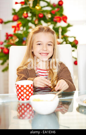 Felice sorridente ragazza di mangiare i cookie a natale Foto Stock