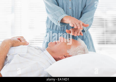 Massaggi terapista esegue Reiki sull uomo Foto Stock